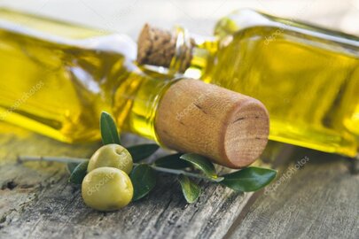 Flasche mit Olivenöl auf rustikalem Holztisch